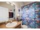 Colorful bathroom featuring an updated vanity, fish-themed shower curtain, and decorative artwork at 10606 Masters Dr, Clermont, FL 34711