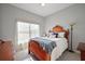 Cozy bedroom featuring a decorative wooden headboard and natural light from sheer window coverings at 10606 Masters Dr, Clermont, FL 34711