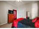 Comfortable bedroom featuring a dark comforter, red accents, and a bright window at 10606 Masters Dr, Clermont, FL 34711