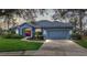 Charming single-story home featuring a manicured lawn, two-car garage, and a welcoming red front door at 10606 Masters Dr, Clermont, FL 34711