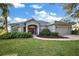 Charming home featuring lush landscaping and an inviting red front door at 10606 Masters Dr, Clermont, FL 34711