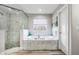 Luxurious bathroom featuring a soaking tub, a glass-enclosed shower, and marble accents at 11101 Versailles Blvd, Clermont, FL 34711