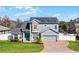 Charming two-story home with stone accents, solar panels, manicured lawn, and welcoming blue front door at 11101 Versailles Blvd, Clermont, FL 34711