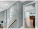 Light-filled hallway with wood floors, neutral walls, and an open doorway to a bedroom at 11101 Versailles Blvd, Clermont, FL 34711