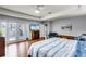 Spacious main bedroom featuring wood floors, a tray ceiling, and private balcony access at 11101 Versailles Blvd, Clermont, FL 34711