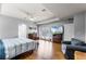 Comfortable main bedroom featuring wood floors, tray ceiling, and balcony access at 11101 Versailles Blvd, Clermont, FL 34711