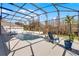 Relaxing screened pool area with lake view, mature trees, and space for outdoor seating at 11101 Versailles Blvd, Clermont, FL 34711