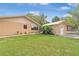 View of the backyard with a detached building, lush lawn, and simple landscaping at 1119 Cr 457, Lake Panasoffkee, FL 33538