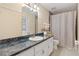 Bathroom featuring a shower/tub with a decorative curtain, single sink vanity, and large mirror at 1119 Cr 457, Lake Panasoffkee, FL 33538