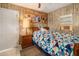 A bedroom with a wooden bed frame, a colorful patterned quilt, and wood-panelled walls at 1119 Cr 457, Lake Panasoffkee, FL 33538