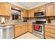 Kitchen area with stainless steel appliances, natural wood cabinets, and stone countertops at 1119 Cr 457, Lake Panasoffkee, FL 33538