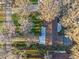 Aerial view of a home with a unique roof and landscaping and a screened pool area at 11243 Dead River Rd, Tavares, FL 32778