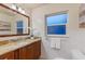 Bathroom featuring a granite countertop, wood cabinets, toilet, and frosted window at 11243 Dead River Rd, Tavares, FL 32778