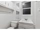 This bathroom features a single sink vanity, a mirror, a toilet, and a shower with white tiling at 11243 Dead River Rd, Tavares, FL 32778