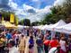 View of a street lined with tents and people at a community street market at 11243 Dead River Rd, Tavares, FL 32778