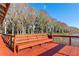 View of waterfront deck with wooden bench, overlooking trees and lake at 11243 Dead River Rd, Tavares, FL 32778