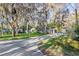 Long driveway leading to a well-kept home surrounded by mature trees and lush landscaping; carport at 11243 Dead River Rd, Tavares, FL 32778