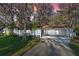 Welcoming exterior with a lush front yard, carport, screened porch, and mature trees draped in Spanish moss at 11243 Dead River Rd, Tavares, FL 32778