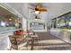 Cozy screened-in patio featuring wicker furniture, ceiling fans, and a view of the backyard at 11243 Dead River Rd, Tavares, FL 32778