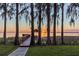 Beautiful waterfront view from the end of a wooden dock, showcasing lush trees and a peaceful lake at sunset at 11243 Dead River Rd, Tavares, FL 32778