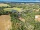 A bird's-eye view of the vast property with a clear pond, lush trees, and open fields at 12220 County Road 209, Oxford, FL 34484