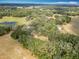 Aerial landscape view showcasing the home's location within a serene, tree-filled area with water features at 12220 County Road 209, Oxford, FL 34484