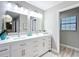 Bright bathroom with dual sink vanity, modern fixtures, and wood-look floors at 12220 County Road 209, Oxford, FL 34484