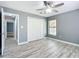 Spacious bedroom with wood-look floors, walk-in closet, and ceiling fan at 12220 County Road 209, Oxford, FL 34484