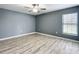 Well lit bedroom featuring a large window with gray walls and wood-look flooring at 12220 County Road 209, Oxford, FL 34484