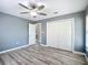 A bedroom with a ceiling fan, wood floors, and a closet at 12220 County Road 209, Oxford, FL 34484