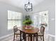 Cozy dining area features a wooden table set, large dresser, and bright lighting at 12220 County Road 209, Oxford, FL 34484