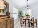 Cozy dining area features a wooden table set, large dresser, and bright lighting at 12220 County Road 209, Oxford, FL 34484