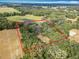 Aerial shot outlining the property lines of the sprawling, tree-lined estate with a tranquil pond at 12220 County Road 209, Oxford, FL 34484