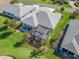 Aerial view of the home featuring a screened-in lanai and well-maintained landscaping at 12390 Se 176Th Loop, Summerfield, FL 34491