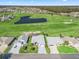 Scenic aerial view of the home featuring a golf course, water feature, and lush greenery at 12390 Se 176Th Loop, Summerfield, FL 34491