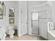 Bright bathroom showcasing an enclosed shower with glass door and a toilet with decorations on the wall at 12390 Se 176Th Loop, Summerfield, FL 34491