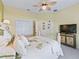 Bright bedroom featuring palm tree decor, a ceiling fan and closet with a door open to the hallway at 12390 Se 176Th Loop, Summerfield, FL 34491