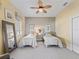 Neutral bedroom featuring twin beds, bedside tables and a large window with blinds and valance at 12390 Se 176Th Loop, Summerfield, FL 34491