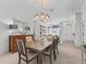 Open dining area with chandelier, wooden table with seating for six, and views into the living spaces at 12390 Se 176Th Loop, Summerfield, FL 34491