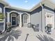 Inviting front porch featuring elegant columns, seating, and decorative potted plants, enhancing the home's curb appeal at 12390 Se 176Th Loop, Summerfield, FL 34491