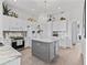 Well-lit kitchen with custom cabinetry, marble backsplash, an island, and modern appliances at 12390 Se 176Th Loop, Summerfield, FL 34491