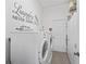 Laundry room featuring a washer and dryer with white cabinets and black and white laundry themed wall decorations at 12390 Se 176Th Loop, Summerfield, FL 34491