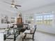 Bright living room featuring large windows, a comfortable sofa, stylish chairs, and an elegant glass coffee table at 12390 Se 176Th Loop, Summerfield, FL 34491