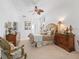 Spacious main bedroom with two dressers, a decorative ceiling fan, and warm color palette at 12390 Se 176Th Loop, Summerfield, FL 34491