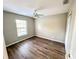 Sunny bedroom with wood floors, a ceiling fan, and a large window at 1263 Legendary Blvd, Clermont, FL 34711