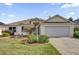 Traditional home featuring a well-manicured lawn, concrete driveway, and a two-car garage at 1273 Oak Forest Dr, The Villages, FL 32162