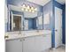 Bathroom featuring dual sinks with white cabinets and a large mirror, offering ample space and style at 1303 Fontana Ct, Lady Lake, FL 32159