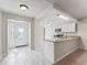 Bright foyer with decorative glass door, neutral walls, and a view into the kitchen with granite countertops at 1303 Fontana Ct, Lady Lake, FL 32159