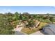 Aerial view of a beautiful home, with a three car garage, palm trees, mature landscaping and paver driveway at 1312 Patrick Pl, The Villages, FL 32162