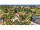 Stunning aerial view of a residence featuring manicured lawns, a screened lanai, and verdant golf course surroundings at 1312 Patrick Pl, The Villages, FL 32162